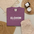 Berry purple Elohim Christian T-shirt with “Creator · Mighty One” typography, styled in a neutral flat lay.