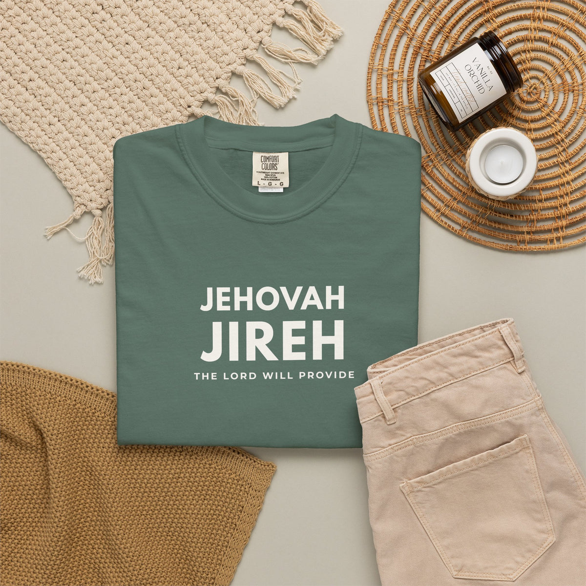Blue spruce green Jehovah Jireh Christian T-shirt with “The Lord Will Provide” typography, styled in a neutral flat lay.