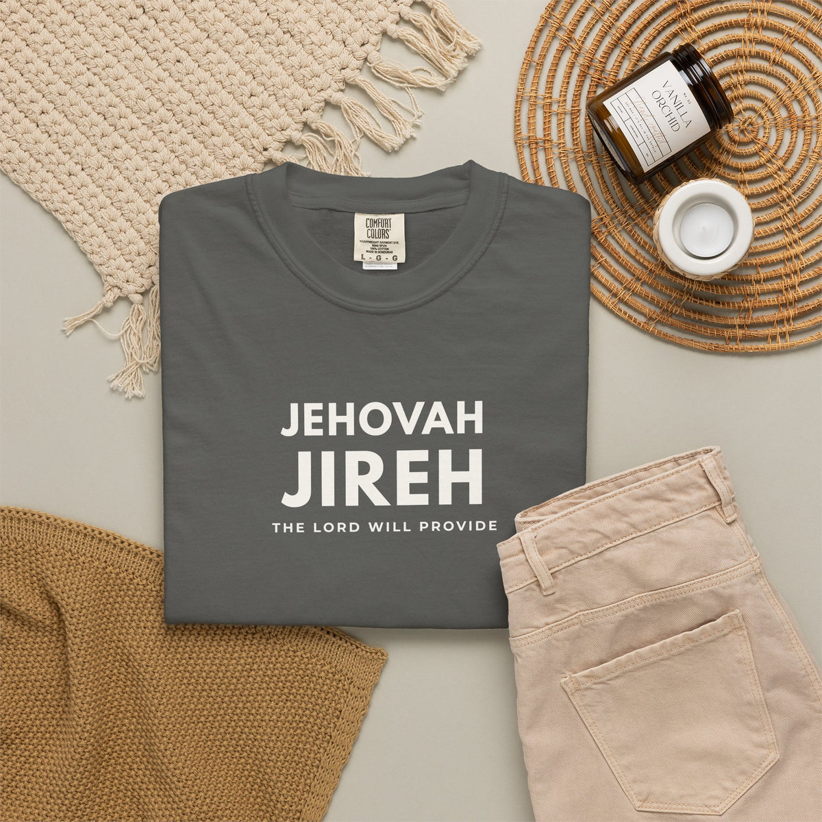 Pepper grey Jehovah Jireh Christian T-shirt with “The Lord Will Provide” typography, styled in a neutral flat lay.