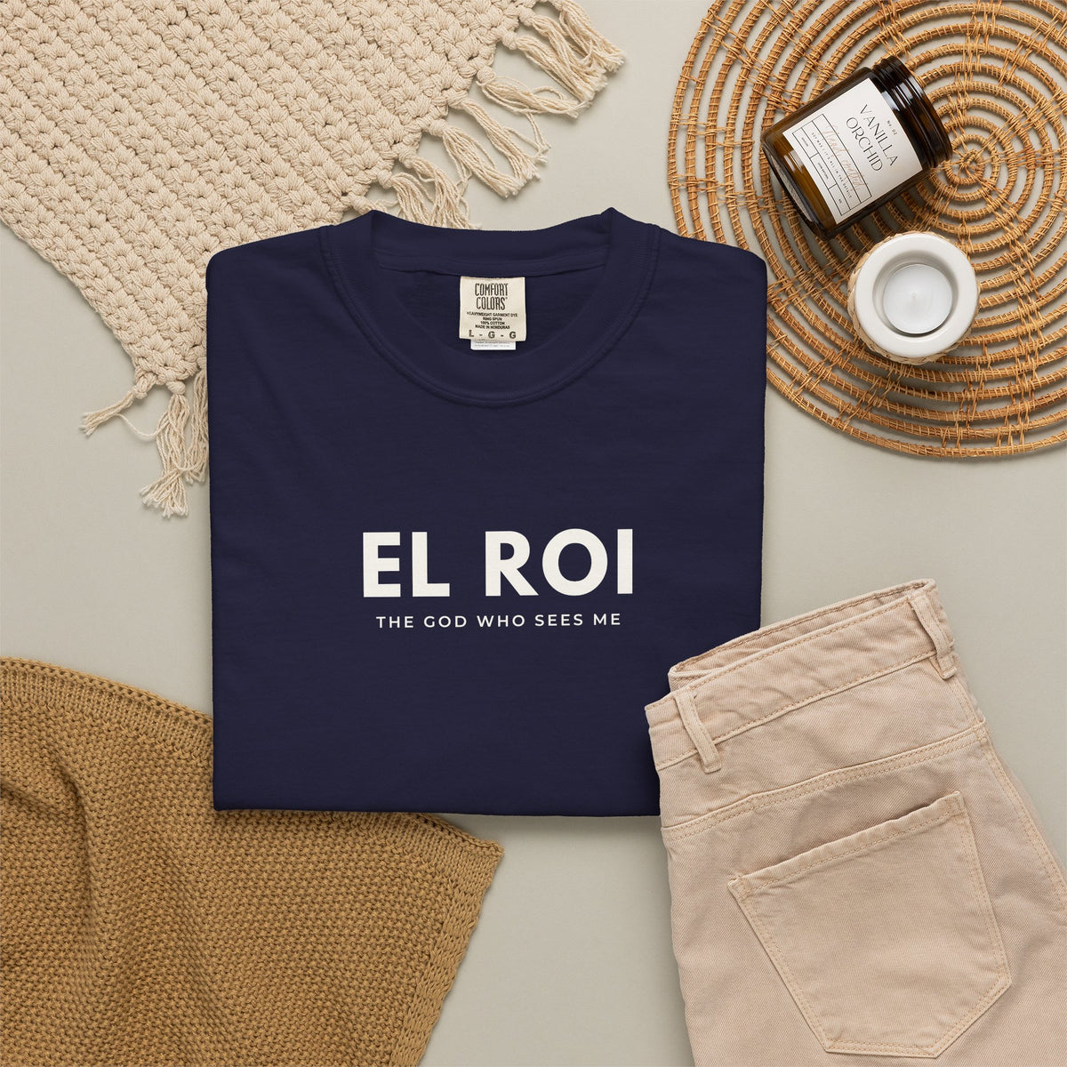True Navy El Roi Christian T-shirt with “The God Who Sees Me” typography, styled in a neutral flat lay.