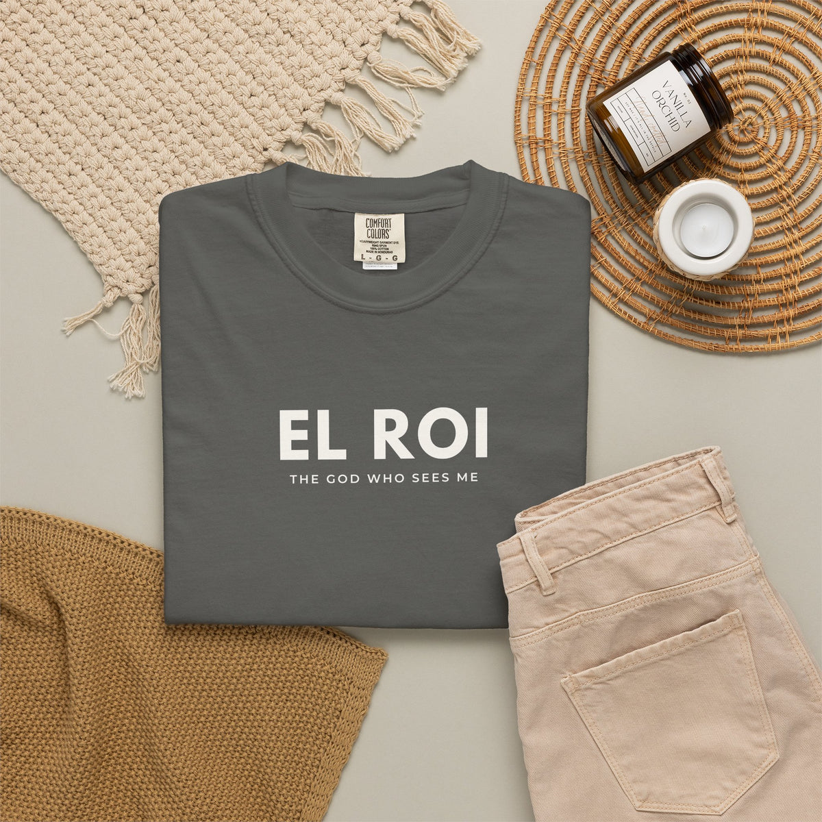 Pepper El Roi Christian T-shirt with “The God Who Sees Me” typography, styled in a neutral flat lay.