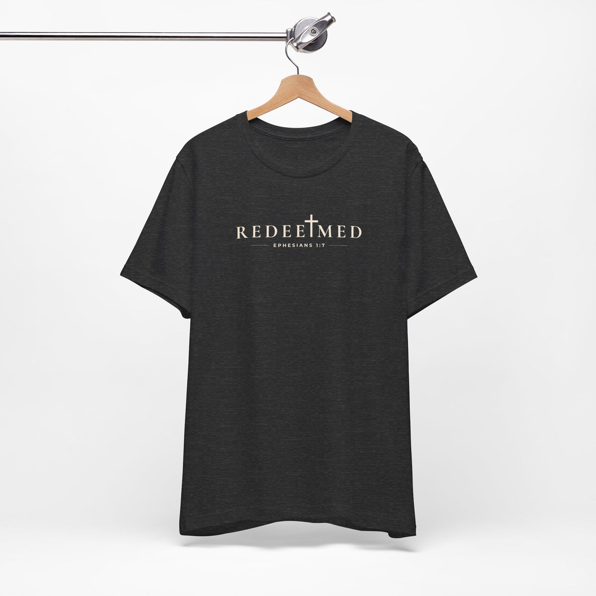 Dark grey heather Redeemed Christian T-shirt with cross detail and Ephesians 1:7 typography on hanger