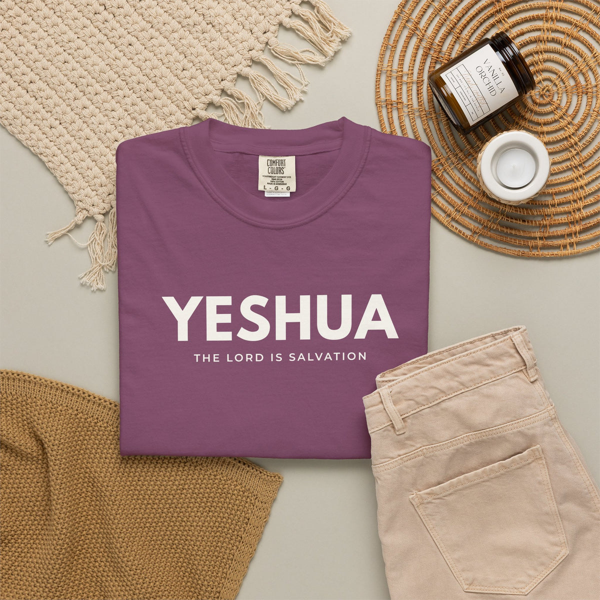 Berry purple Yeshua Christian T-shirt with “The Lord Is Salvation” in white, styled with beige jeans and neutral accessories.