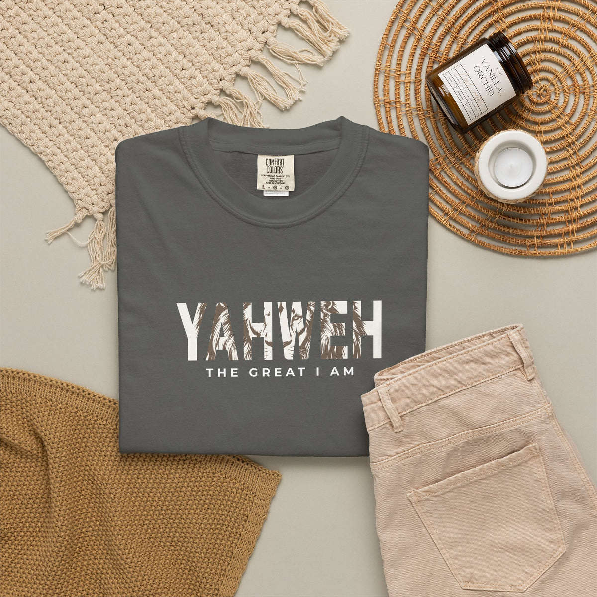 Charcoal grey Yahweh Christian T-shirt with “The Great I Am” in white, styled with beige jeans and neutral accessories.