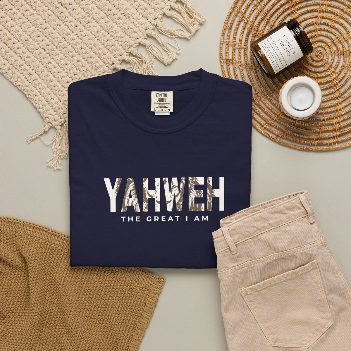 Navy blue Yahweh Christian T-shirt with “The Great I Am” in white, styled with beige jeans and neutral accessories.