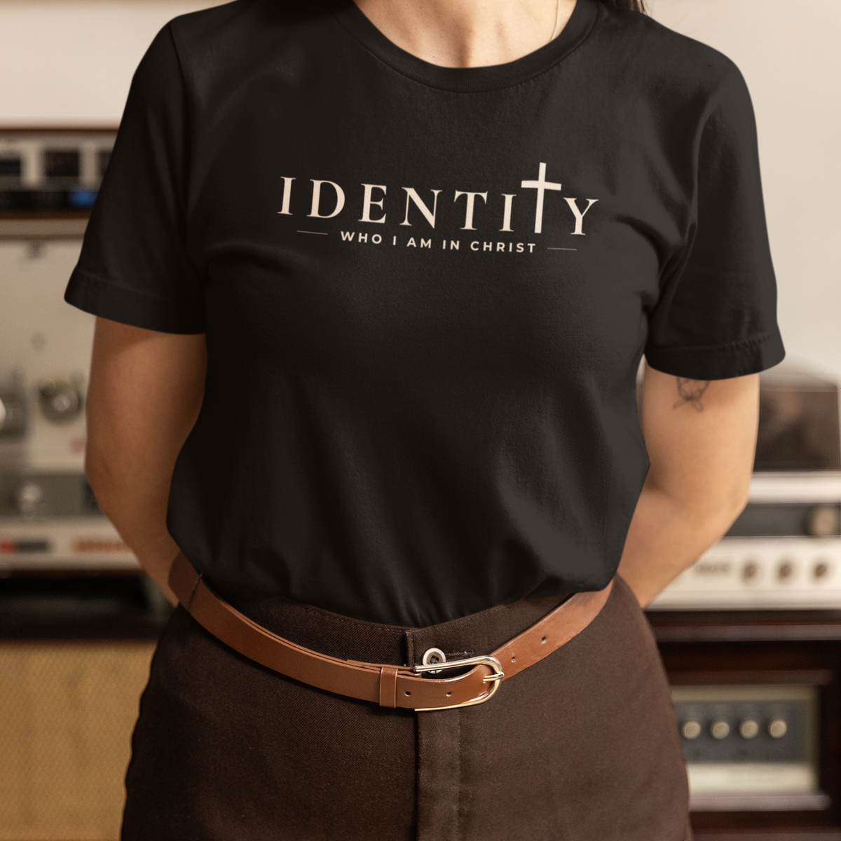 Woman wearing black Identity Christian T-shirt with cross detail and “Who I Am in Christ” typography