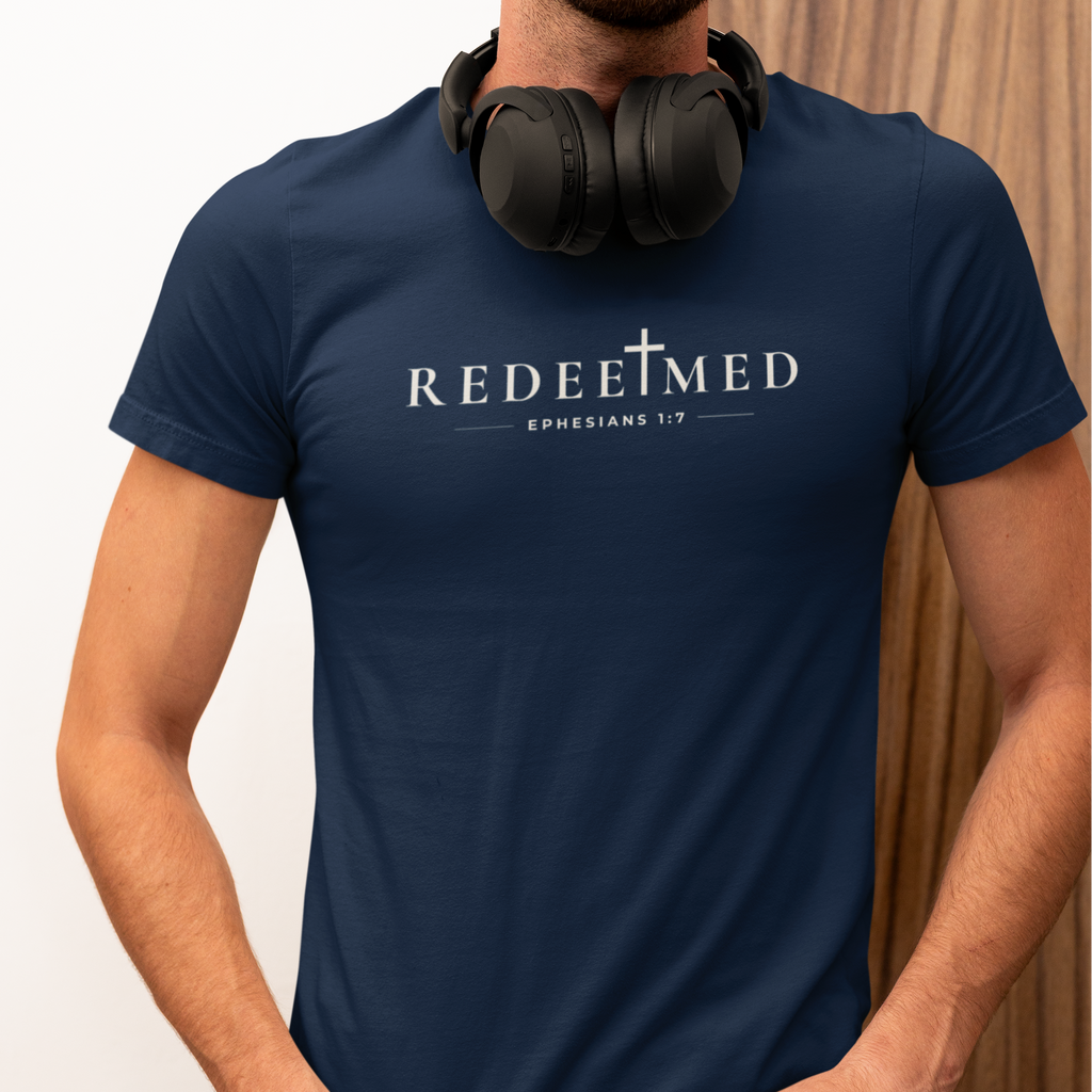 Man wearing navy Redeemed Christian T-shirt with cross detail and Ephesians 1:7 typography