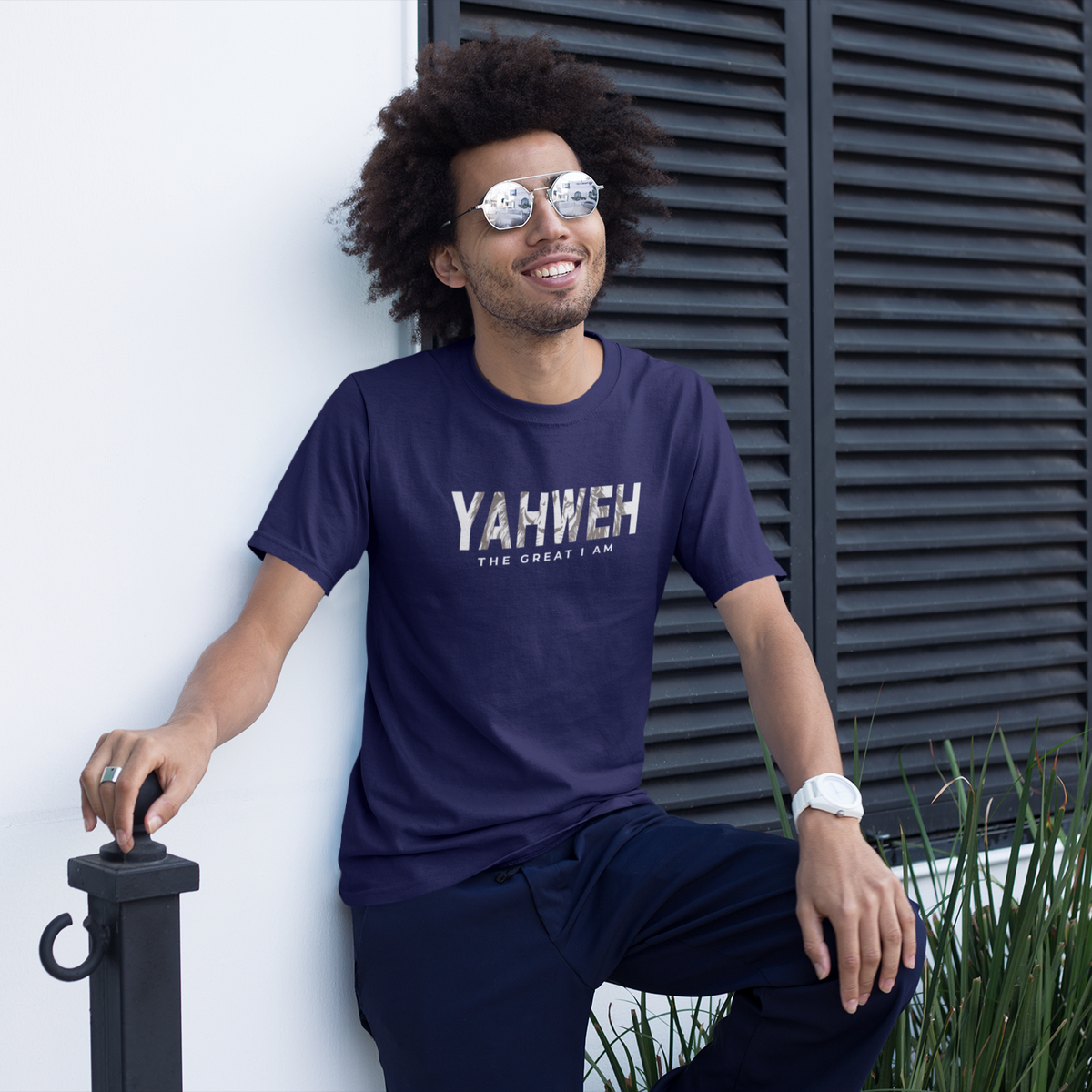 Smiling man wearing a navy blue Yahweh Christian T-shirt with “The Great I Am” graphic printed on the front.